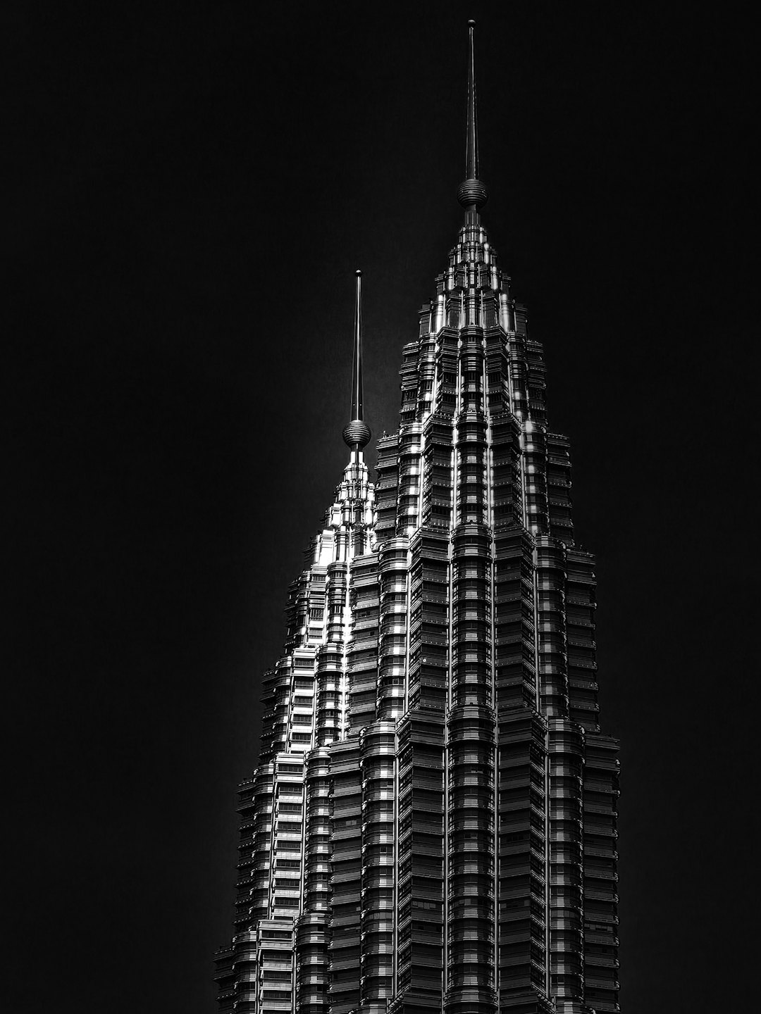 The twin spires of a modern skyscraper reach toward the sky.